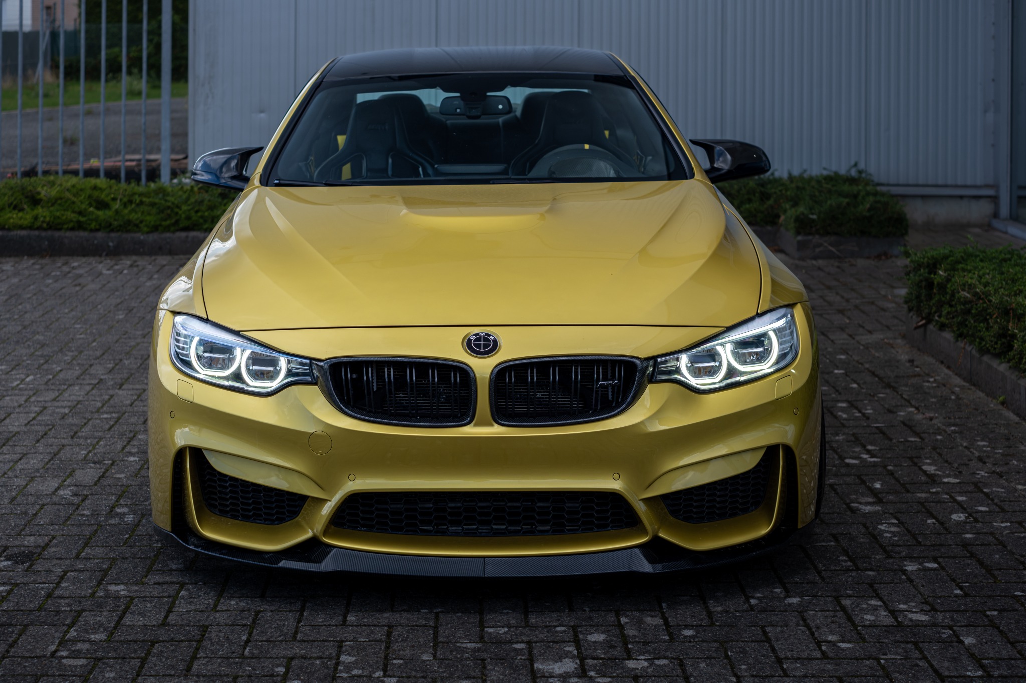 BMW M4 frontaanzicht in goudgeel