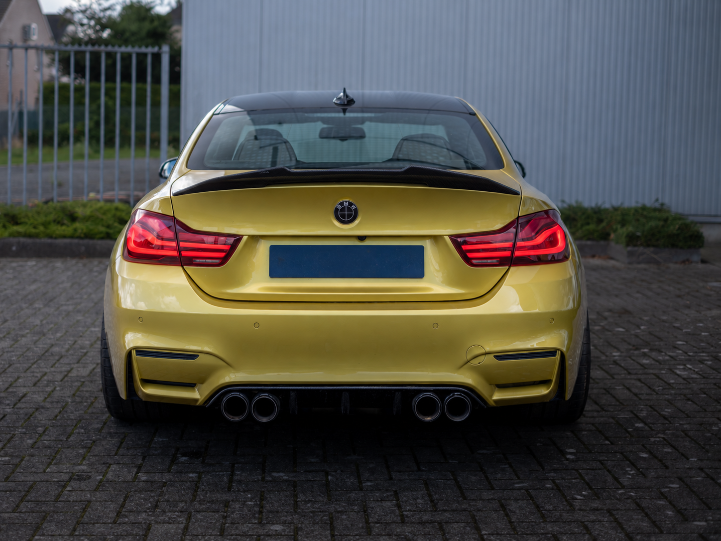 BMW M4 achteraanzicht in goudgeel