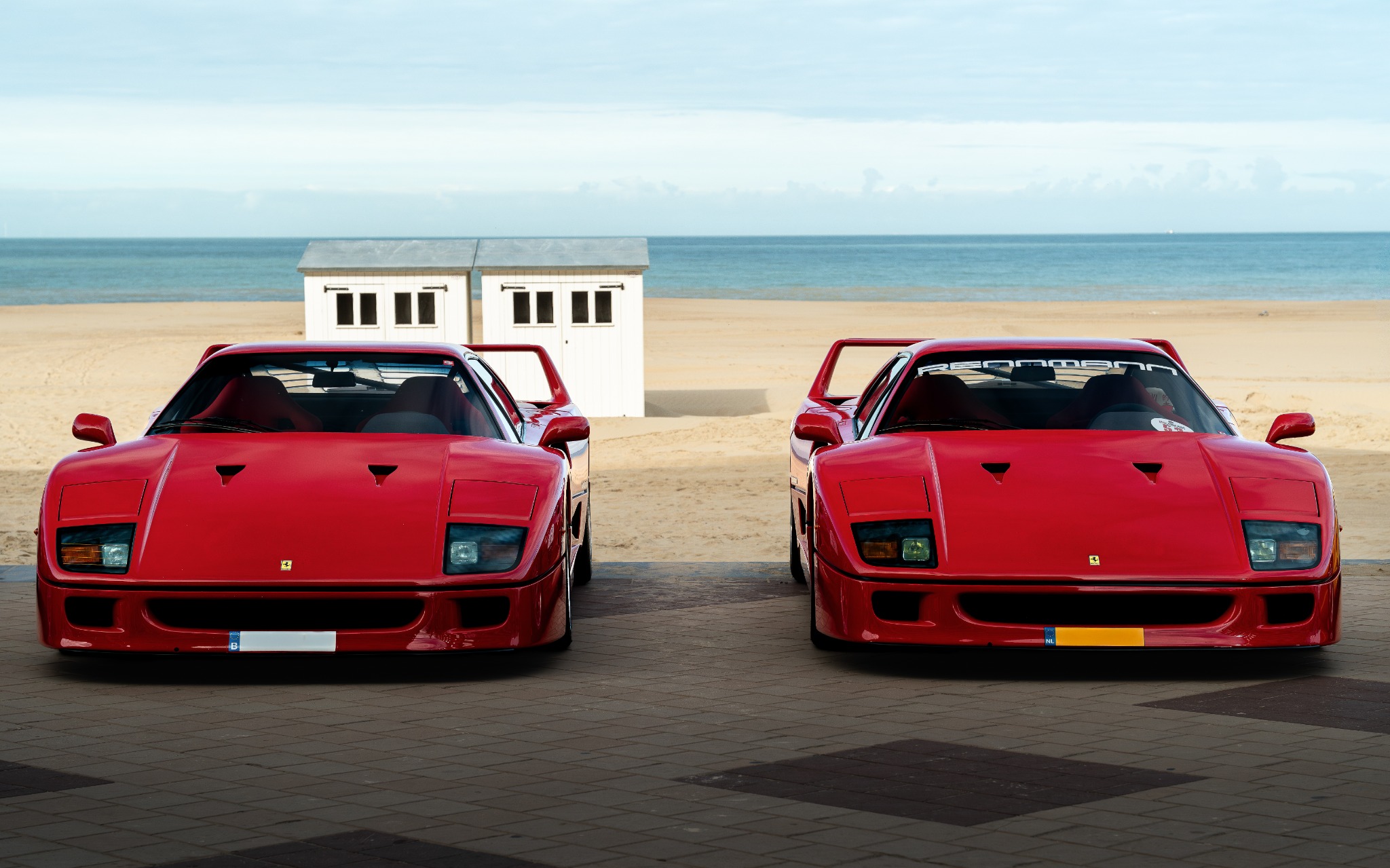 Twee rode Ferrari F40's aan de kust